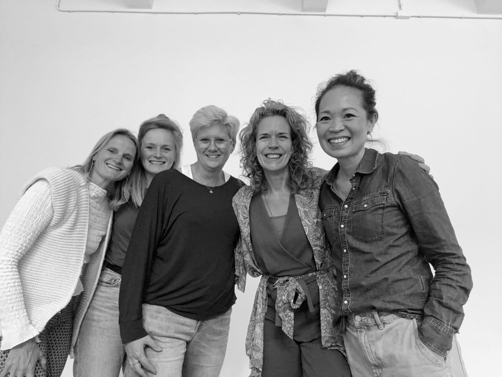 Vijf vrouwen uit de community, arm in arm