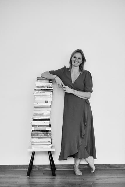 Kim Helmer leunend op een stapel boeken