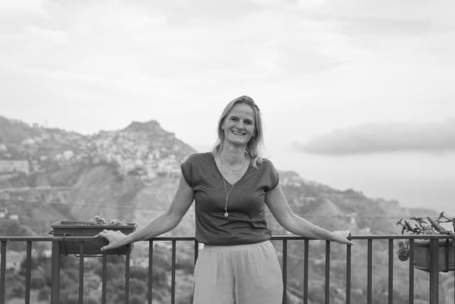 Kim Helmer op een terras met uitzicht over de kust